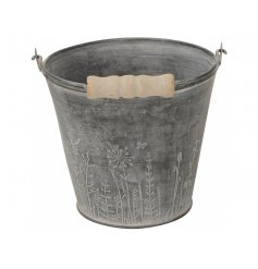 A rustic grey metal bucket planter with a vintage inspired wooden handle. Decorated with a stunning wild flower design.