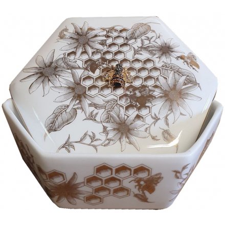 A stylish hexagon shaped ceramic trinket box and lid with an added luxe golden beehive inspired decal 