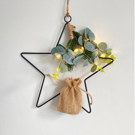   A large black wire Star complete with a eucalyptus foliage and warm glowing LED lights 