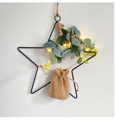   A large black wire Star complete with a eucalyptus foliage and warm glowing LED lights 