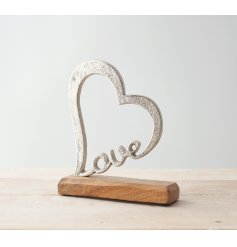 a rough set aluminium heart ornament with a scripted love wording and added wooden block base