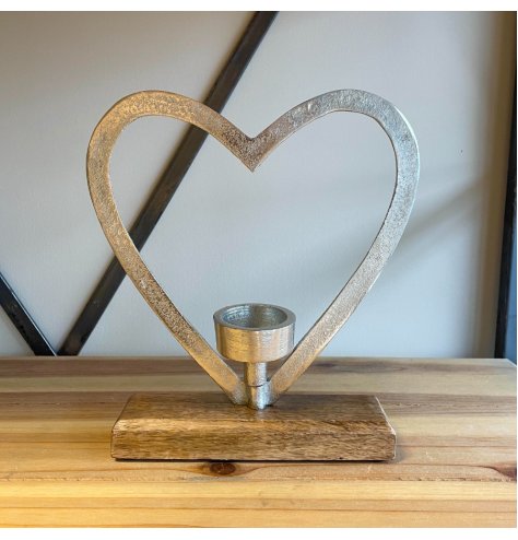 A chunky aluminium heart outline stood on a wooden base with a T-light centred inside.
