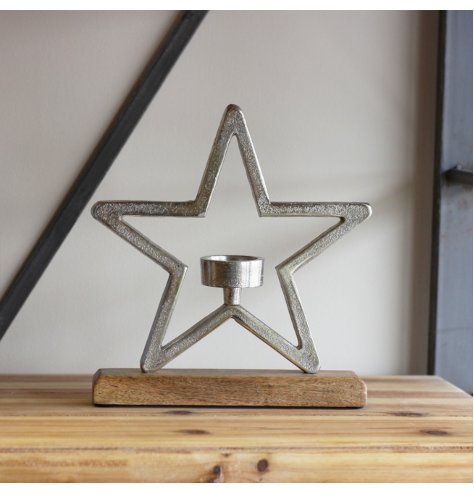A chunky aluminium star outline stood on a wooden base with a T-light centred inside.