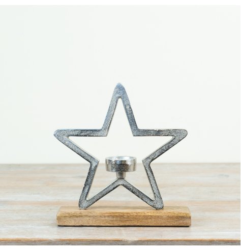 A chunky aluminium star outline stood on a wooden base with a T-light centred inside.
