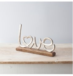 A sleek Love Scripted Ornament set upon a natural wooden block base 
