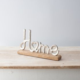 A sleek Home Scripted Ornament set upon a natural wooden block base 