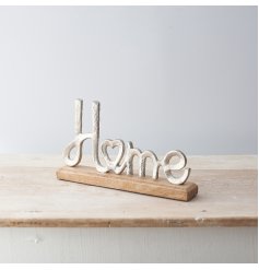 A sleek Home Scripted Ornament set upon a natural wooden block base 