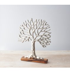 a silver toned aluminium tree of life ornament on a block wooden base 
