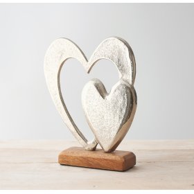   An ornamental aluminium double heart ornament set on a natural wooden block base 