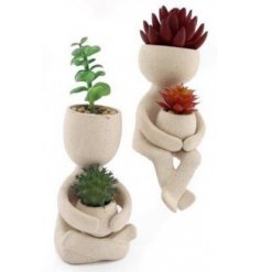 an assortment of figure shaped pots with spiked artificial succulent hair 