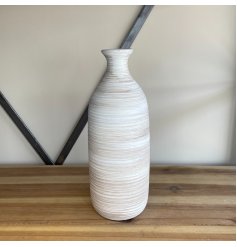 A tall standing ribbed vase with a neutral colour tone and a rustic finish 