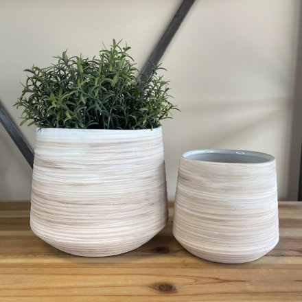 A set of assorted sized round pots with a ribbed touch finish and neutral colour theme 