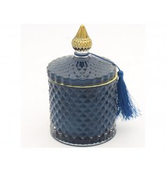 A sleek blue toned diamond ridge candle holder complete with gold accents and a fuzzy tassel 
