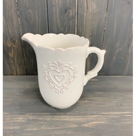 A beautiful yet simple ceramic jug featuring a scalloped edging and a charming embossed heart central decal 