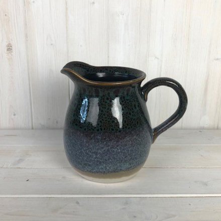 A decorative stoneware jug covered with a reactive blue glaze coating 