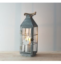 a tall standing metal lantern with a white washed finish and chunky rope handle