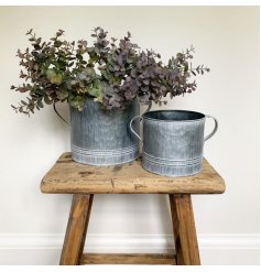a small decorative metal pot with an overly distressed setting and tapered ear handles 
