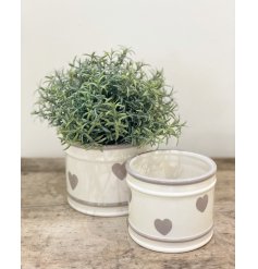  A small rounded ceramic pot featuring a faded grey heart print and added ridged edges 