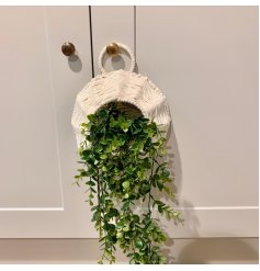 A simple yet chic hanging woven basket with an artificial draping eucalyptus set within it 