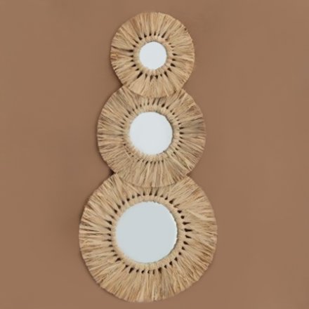 A set of 3 assorted sized mirrors decorated with a dried grass surround and circular design 