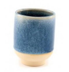 A small decorative ceramic vase featuring a reactive blue glazing and natural toned base 