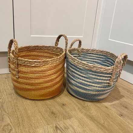 An assorted sized set of woven baskets with a orange hue to each 