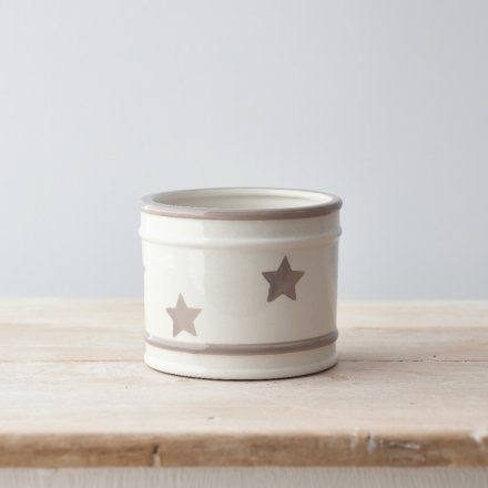 A charmingly simple round ceramic pot featuring a faded grey star decal around it 