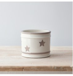A charmingly simple round ceramic pot featuring a faded grey star decal around it 