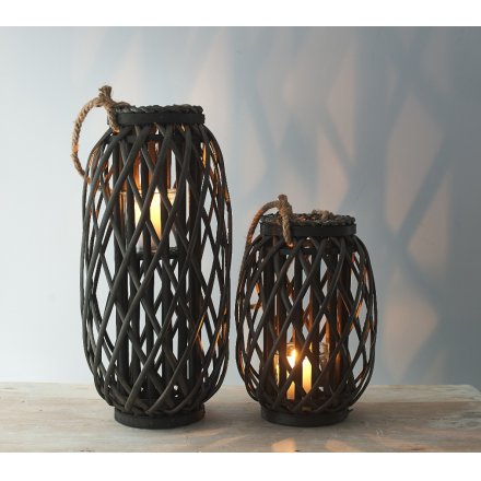 a tall standing wooden lantern with a lattice pattern and chunky rope handle 