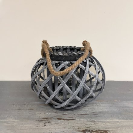  A small rounded lantern featuring a lattice willow decal and chunky rope handle 