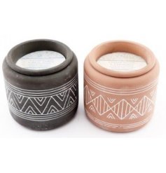 An assortment of terracotta based candles, each set with am embossed Aztec inspired print 