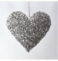 A grey toned wicker wrapped heart hung from a simple jute string 