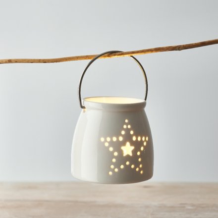  A small and simple ceramic T-light holder decorated with a dotted star motif 