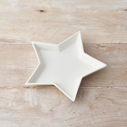 A small ceramic star shaped trinket dish, perfect for placing in any home space needing to keep trinkets safe 