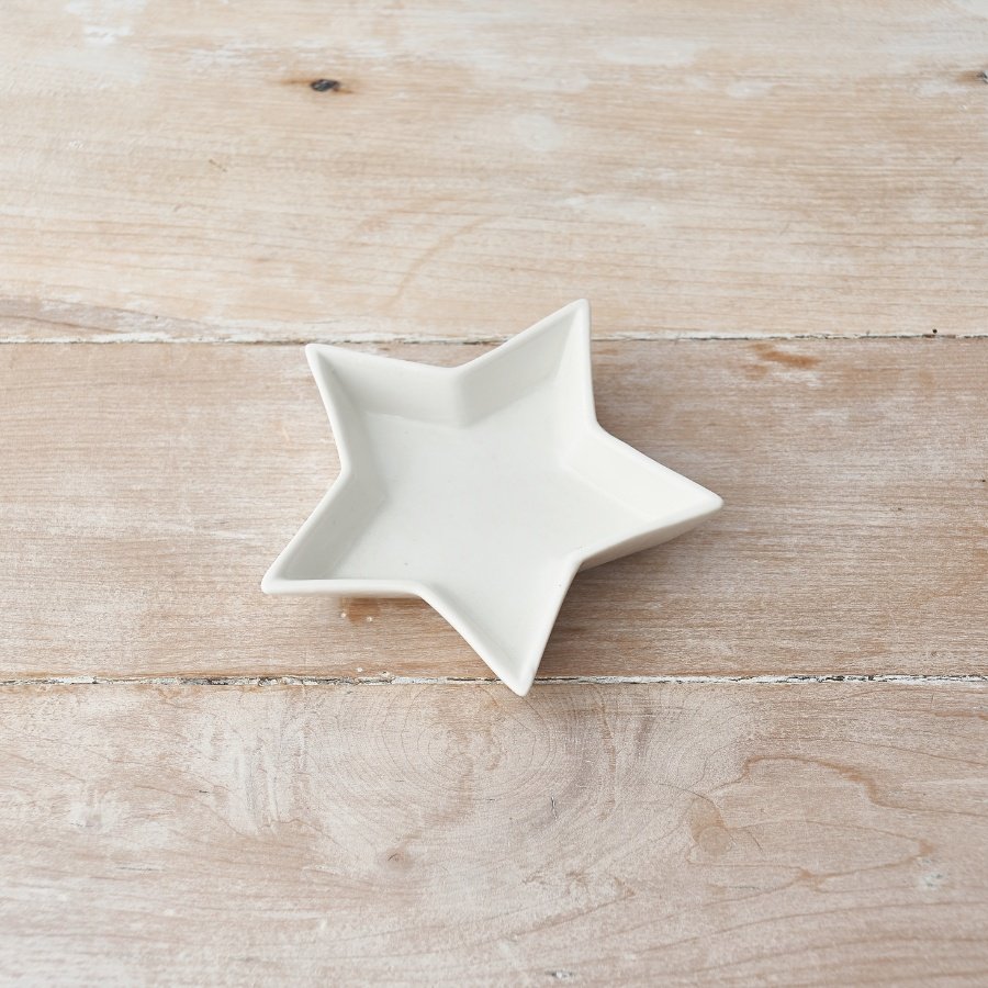 A small ceramic star shaped trinket dish, perfect for placing in any home space needing to keep trinkets safe 