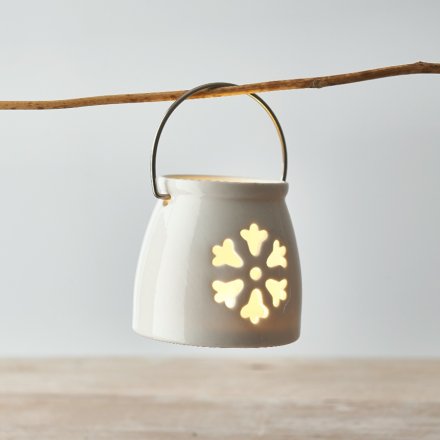 A small ceramic T-light holder featuring a snowflake shaped cut decal 