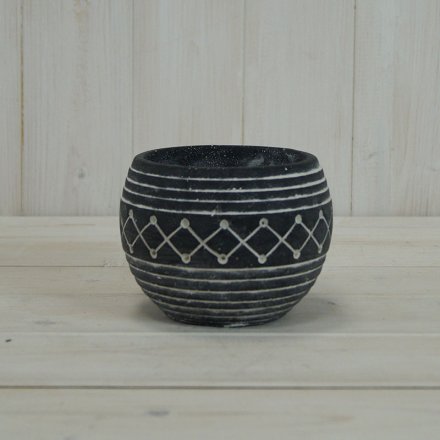 A rounded bowl shaped planter featuring an overly distressed black tone and aztec inspired decal to finish 