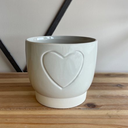 A small ceramic pot featuring a smooth finish and subtle embossed heart design 