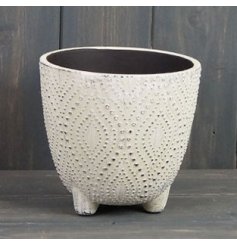   A small offwhite toned pot featuring based feet and a pretty dotted decal with a rustic touch 