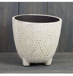 A footed pot featuring a charmingly rustic dotted decal around it 