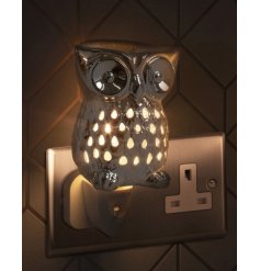 A plug in aroma lamp in a cute owl form, with a dipped dish on top and a warm white light shining through 