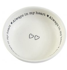 A small round ceramic trinket dish featuring a script text surrounding decal and added linked hearts in the centre
