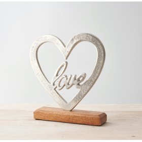 Set upon a natural wood block base, this heart ornament is perfect for bringing to any home space