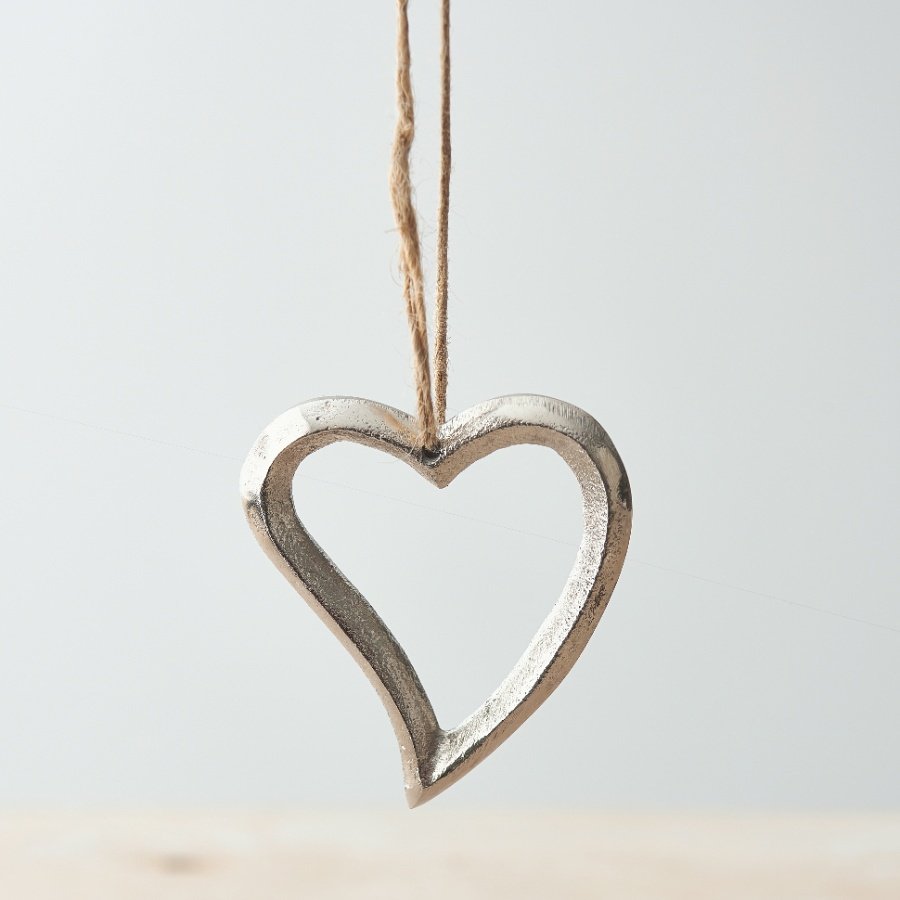 A luxe silver hanging heart decoration made from metal. Complete with a jute string hanger.