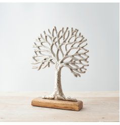  A large ornamental silvered tree decoration placed on top a natural wooden block 