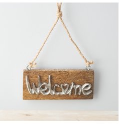A small and simple natural wooden block plaque featuring a rustic metal welcome text decal 