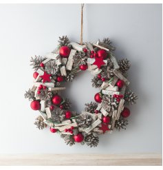 A large decorative wooden wreath with added bold red tones and festive accents 