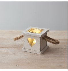 A rustic wooden tray set with heart cut decals, chunky rope handles and spaces for candles