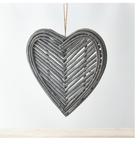 A heart shaped wreath decorated with patterned twigs and a jute string for hanging