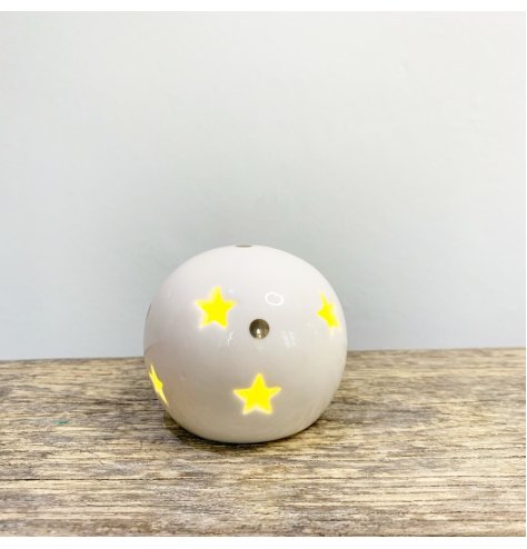 A ceramic ball with star cut decals, gold dots features and a warm glowing LED centre 